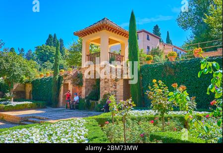 GRANADA, SPAIN - SEPTEMBER 25, 2019: The viewing pavilion amid the lush greenery, topiary shrubs and flower beds of  Partal garden of Alhambra, on Sep Stock Photo