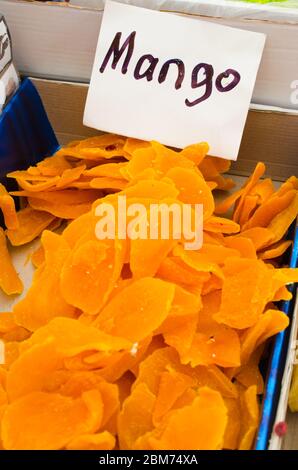 Sweet slices candied mango. Dried fruits on market. Selective focus. Stock Photo