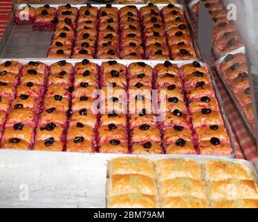 Tray in the showcase with turkish traditional dessert, baklava, cataif sweet honey deserts during food festival, street food specialties Stock Photo