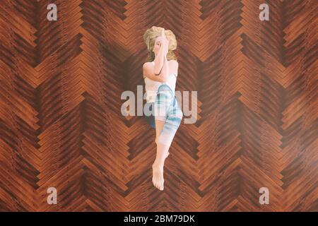 woman in yoga pose on wooden platform Stock Photo