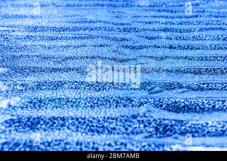 Photo of holographic real texture in blue colors, colorful iridescent surface. Holographic color wrinkled foil. Colored glitter. Shining background. Stock Photo