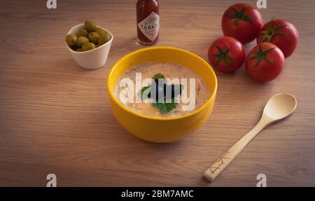 a bowl with tuna sauce and some ingredients around on the table Stock Photo