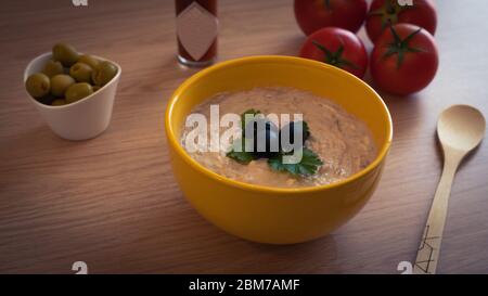 a bowl with tuna sauce and some ingredients around on the table Stock Photo