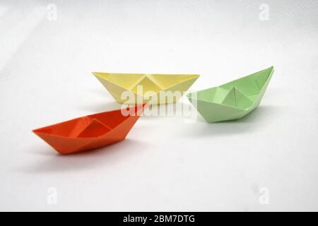 Colorful paper boats. Paper boats in a various colors on a white background. Stock Photo