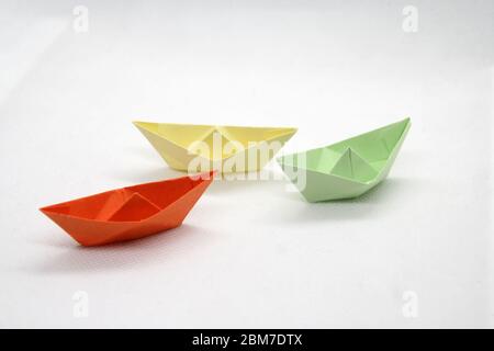 Colorful paper boats. Paper boats in a various colors on a white background. Stock Photo