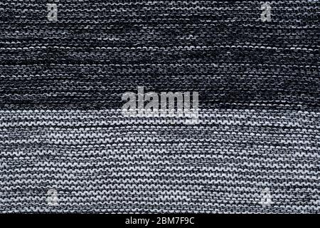 Black and white knitted texture, wallpaper. Abstract knitwear background. Gray jersey Stock Photo
