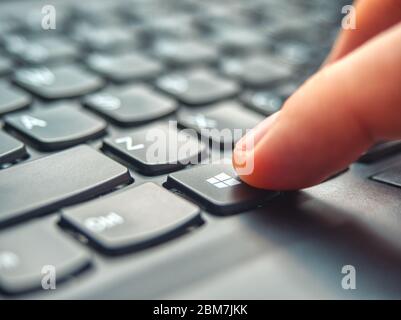 Galati, Romania - April 06, 2020: Laptop user pressing Windows Key on Microsoft Windows keyboard Stock Photo
