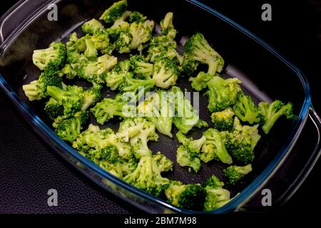 green broccoli n a glass plate on a black background Stock Photo