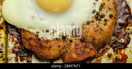 Fried portion of gammon served with egg on the metal plate, english meal Stock Photo
