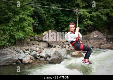 Rize / Turkey- August 6 2019: Tourist girl gliding on the zip line trip on Firtina valley Stock Photo