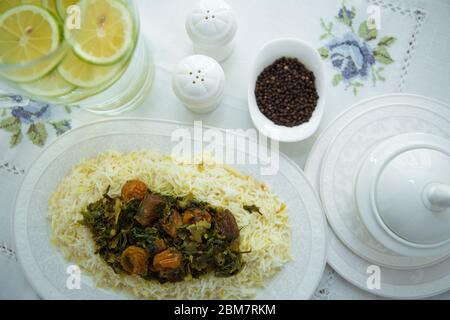 A bowl of white ceramic salt and pepper. Shah pilaf. Khan pilaf in a pita. Black pepper in a white ceramic pot . There is meat and plum chestnuts on Stock Photo