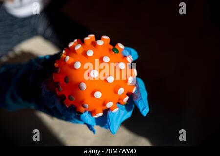 Red bright spiny ball isolated on dark background. Toy, close-up. Coronavirus model.model of the SARS-CoV-2 virus ,toy model. quarantine, isolation Stock Photo