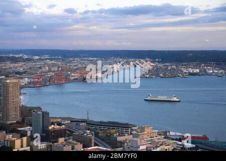 Arial view of Seattle from the Space Needle just before sunset with dark clouds moving in against a blue sky