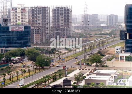 shot showing the empty streets and intersection moving to sky scrapers with resedences, homes, offices and more in the modern city of gurgaon Stock Photo