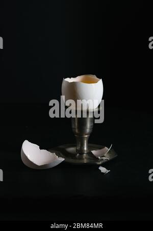 still life, raw egg in a stand on a dark background Stock Photo