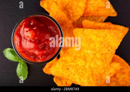 Tortilla chips and one glass bowl filled with salsa sauce - top view Stock Photo