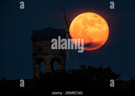 The full moon, also known as the Supermoon or Flower Moon, rises over Chesterton Windmill, Warwickshire. Stock Photo