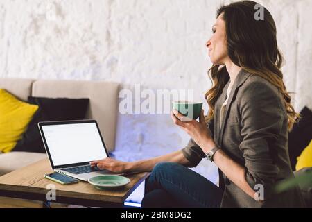Cheerful skilled middle aged life or business coach enjoying creative process of making new text, sitting at workspace, writing down thoughts, ideas Stock Photo