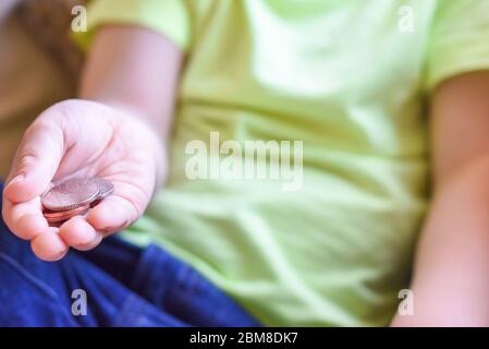 Child holding money in hand cash is UK currency coins Stock Photo
