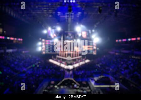 Blurred background of an esports event - Big illuminated main stage of a computer games tournament located on a big stadium. Tribunes are full of Stock Photo