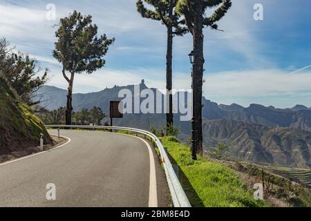 View of the center of Gran Canaria. Famous Roque Nublo - Cloudy rock in huge caldera. In the foreground are several charred pine trees along a mountai Stock Photo