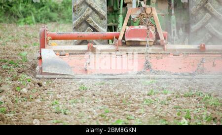 Farmworker riding tractor tilling or plowing the earth. Preparation to cultivate in agricultural field. Traditional agriculture in Spain. Stock Photo