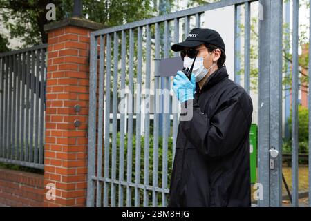 Security Guard In Face Mask Talking On Walkie Talkie Stock Photo