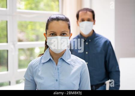 Two People Standing In Line Wearing Face Masks Stock Photo