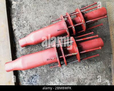 Red painted stainless steel pipe expansion oil seal joints with control rods for steam and heat pipelines Stock Photo