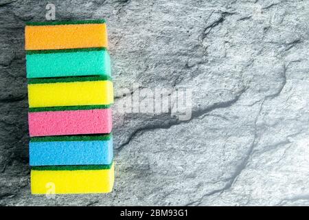 Colored sponges for the kitchen on the background of the table in the color of white marble. Top views with clear space Stock Photo