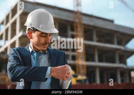 Young construction engineer with yellow helmet crane and construction background , Turkey,Civil engineer ,construction Plan Stock Photo