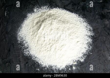 White flour sprinkled on a dark wooden table. top view Stock Photo