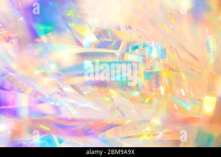 Rich vibrant polished elegant abstract background texture of holographic holiday foil ribbon decoration in pastel gold, aqua and purple colors with sh Stock Photo