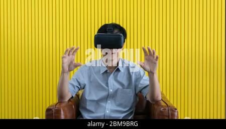 Senior Asian man using tablet and virtual reality simulator playing games in living room and feeling happy . Lifestyle Senior family at home concept. Stock Photo