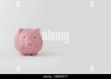 Close-up of pink piggy bank stands on white background. Concept successful cash contribution and accumulation and seed capital for business. Advertisi