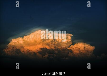A beautiful pictue of clouds with golden rays moving in sky Stock Photo
