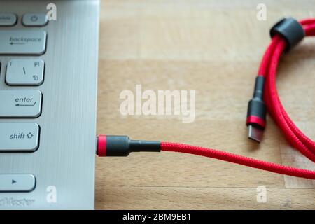 The USB type c is a hi speed data transfer and quick or fast charge battery.It a new connector port of a computer , laptop, or cell phone.A red cable Stock Photo