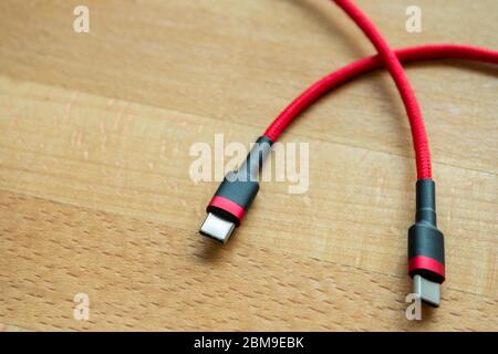 The USB type c is a hi speed data transfer and quick or fast charge battery.It a new connector port of a computer , laptop, or cell phone.A red cable Stock Photo