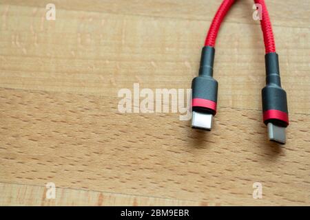 The USB type c is a hi speed data transfer and quick or fast charge battery.It a new connector port of a computer , laptop, or cell phone.A red cable Stock Photo