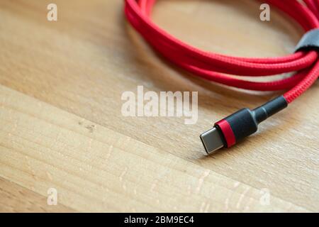 The USB type c is a hi speed data transfer and quick or fast charge battery.It a new connector port of a computer , laptop, or cell phone.A red cable Stock Photo