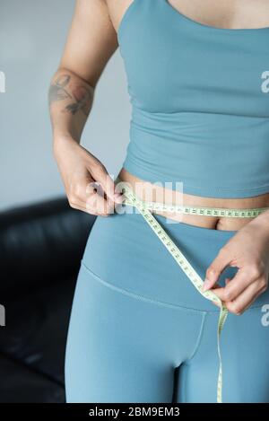 A young Asian woman measures the waist with a ruler Stock Photo