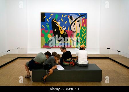 The Sorrows of the King by Henri Matisse display in the gallery of Pompidou Centre with a family gathering on the stool in front of it.Paris.France Stock Photo