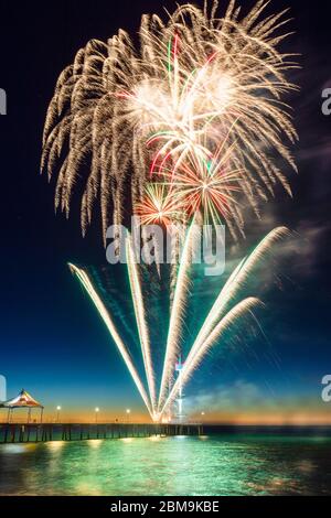 Colourful New Years Fireworks Display lighting up the sky and water off Brighton Jetty, Adelaide, South Australia Stock Photo