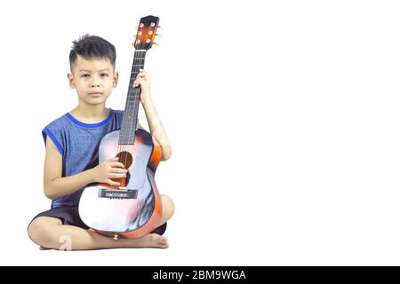 The hands of asian boy holding a guitar and sitting on a white background with clipping path. Stock Photo