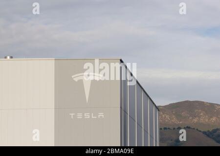 The Tesla sign seen at Tesla Factory in Fremont, California. Tesla, Inc., is an American electric vehicle and clean energy company based in Palo Alto. Stock Photo