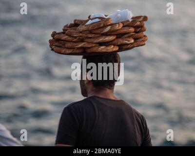 ISTANBUL, TURKEY - SEPTEMBER 21, 2019: Turkish bagel seller with a tray on his head. Stock Photo