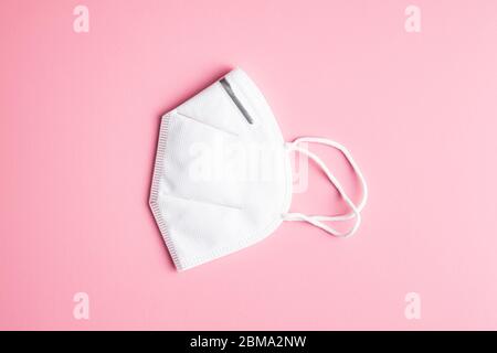 Kn95 protection mask. White respirator on pink background.