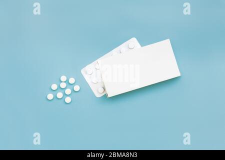 Flat lay mock up template of isolated medicine packaging, blister and pills on blue background Stock Photo