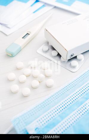 Medicine package, blister, pills, thermometer and face mask for coronavirus (covid-19) pandemic prevention and treatment Stock Photo