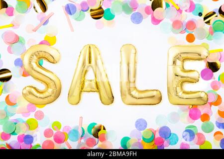 Word SALE made of golden inflatable balloon letters in a frame made of colorful confetti Stock Photo